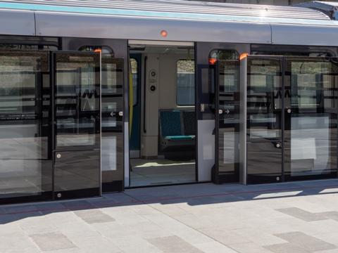 A close up view from the platform displaying the safety screen doors opened as a Sydney Metro train has stopped and opened it's doors at the platform. 