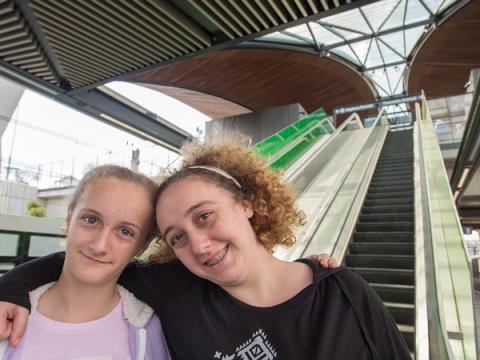 Two members of the community standing in front of the escalators at Sydney Metro's Tallawong Station as part of the community day event.
