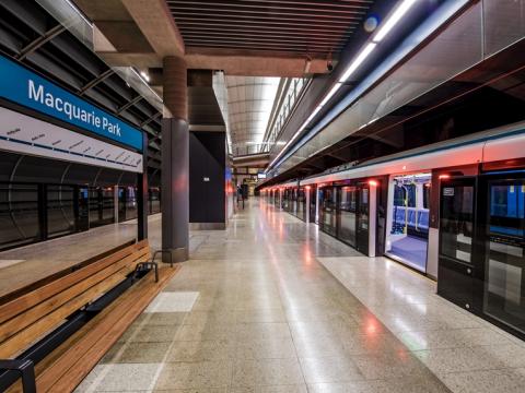 An artist's impression from the platform behind the screen safety doors opened as a train has stopped at the platform showing the platform benches at Sydney Metro's Macquarie Park Station.