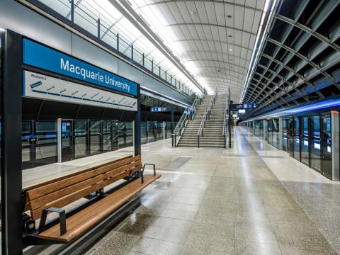 An on the ground shot from the platform behind the screen safety doors showing the platform benches at Sydney Metro's Macquarie University Station.