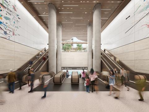 Artist's impression of commuters walking down the Pitt Street North Station Escalators. There are four escalators going down to the platforms in the middle and two escalators on either side that are going up to street level.