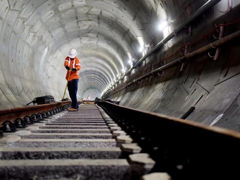 An on the ground view of a construction worker completing track work inside the first Sydney Metro tunnel track. 