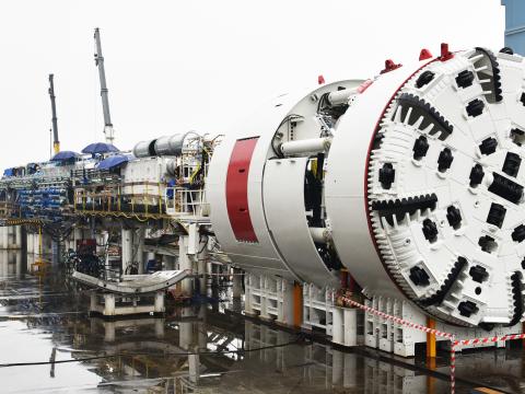 An on the ground view looking at Sydney Metro's tunnel boring machine being put together on a rainy day.