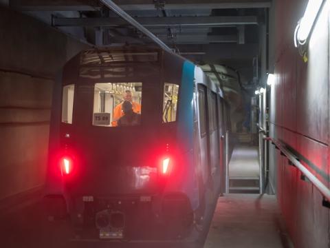 A Sydney Metro train being tested by two Sydney metro employees inside a tunnel. 
