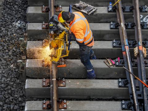 Sparks fly as construction workers use a grinder on the metal tracks at Bankstown Station.