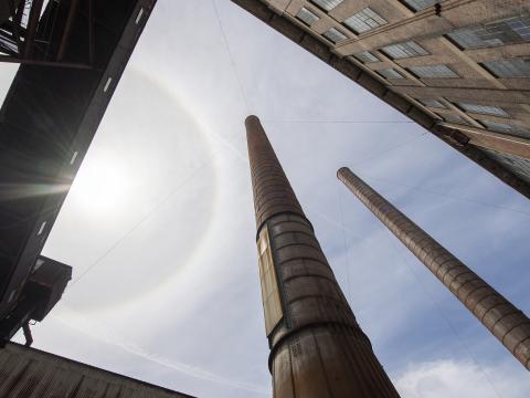 A view from the ground looking up at the sky at large smoke stacks at White Bay Power Station.