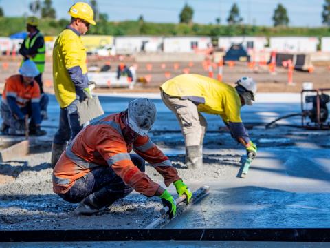 Construction workers levelling wet concrete on Eastern Creek Precast grounds