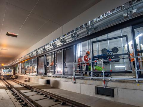 Construction workers installing platform screen doors at Sydney Metro's Waterloo Station