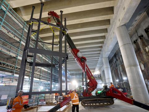 Steel structures are craned into position inside Barangaroo Station's underground cavern