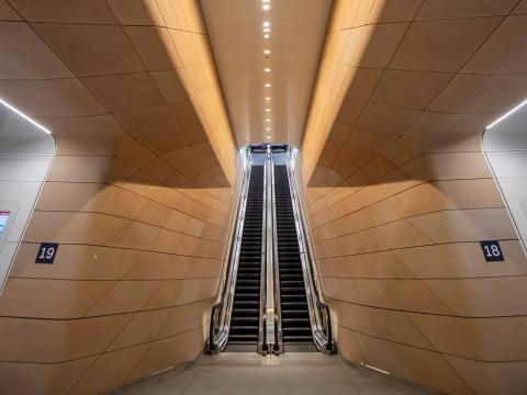 Long vertical shot of escalators and wall panelling in the underground pedestrian concourse at Central Station.