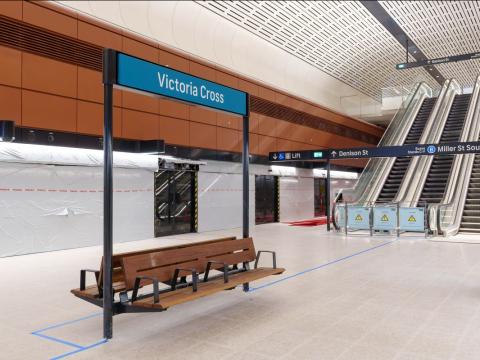 Victoria Cross Station signage above a wooden bench at the platform
