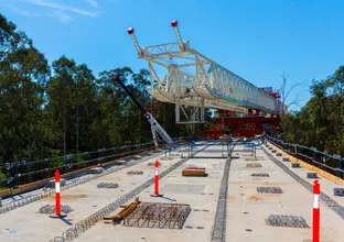 An on the ground view showing the metal structure of the first span of Sydney Metro's skytrain completion.