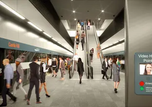Artist's impression showing the Video Help point on a pilar with a red emergency stop button or a green information button with commuters in the background moving along the platform and up the platform escalators at Sydney Metro's Castle Hill Station. 