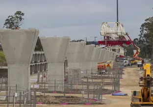 The segments for the skytrain are being put into place by heavy machinery.