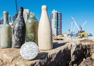 5 old glass bottles and an old jar that reads 'Josephson's Australian Ointment' are on display at the excavation area at the future site of Barangaroo Metro Station.