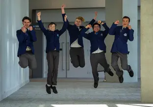 A group of five students jumping for joy as the winners of they Metro Minds Steam challenge.