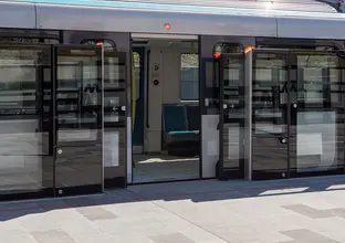A close up view from the platform displaying the safety screen doors opened as a Sydney Metro train has stopped and opened it's doors at the platform. 