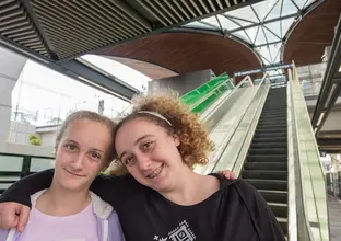 Two members of the community standing in front of the escalators at Sydney Metro's Tallawong Station as part of the community day event.