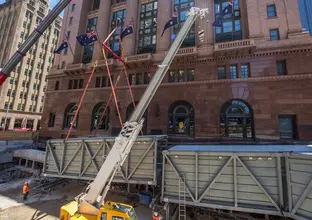 Pedestrian walkway being craned into place at the construction site of Sydney Metro's Martin Place Station. 