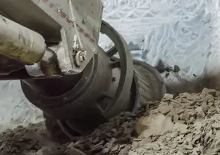 A close up shot of the Roadheader in action as it breaks apart a wall with shattered material beneath it at Sydney Metro's Pitt Street North construction site.