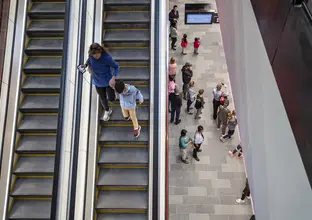 A mother holds hands with her son while walking down the escalators at Castle Hill Station.