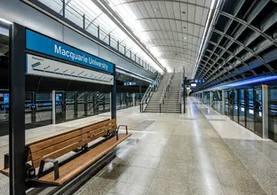 An on the ground shot from the platform behind the screen safety doors showing the platform benches at Sydney Metro's Macquarie University Station.
