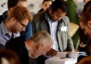 A close up shot showing community members grouped together as they are reading information booklets at a Sydney Metro Community Information Session.