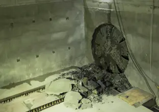 The cutterhead on tunnel boring machine Elizabeth can be seen breaking through the wall in the station box cavity