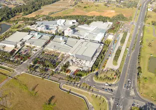 An aerial view of Rouse Hill Station surrounded by green fields and trees.
