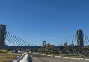 An on the ground view looking across at the completed bridge cable instillation running down the bridge towers at Sydney Metro's Rouse Hill Station. 