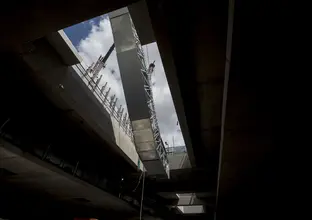 An on the ground view looking up at the escalators being craned into place at Sydney Metro's Norwest Station.