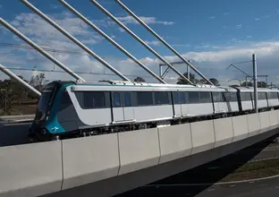 An arial view looking directly across a Sydney Metro train being tested on the completed tracks at Windsor Road Bridge.