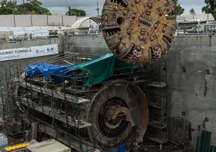 The cutterhead from tunnel Boring Machine (TBM) 2 Florence is being removed by a crane at Cherrybrook Station construction site.