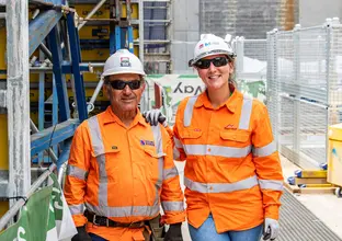 Two construction workers smiling on site on B3 level at Sydney Metro's Waterloo Station.