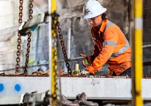 Construction worker in hard hat installing platforms at Barangaroo Station.