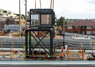 Crane and construction workers positioning a 45-metre-long footbridge into place at Dulwich Hill Station