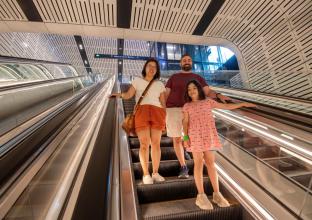 Family of three going down the escalator