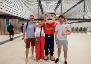 Mascot with three people posing for a photo