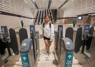 a young girl tapping in to enter the metro station