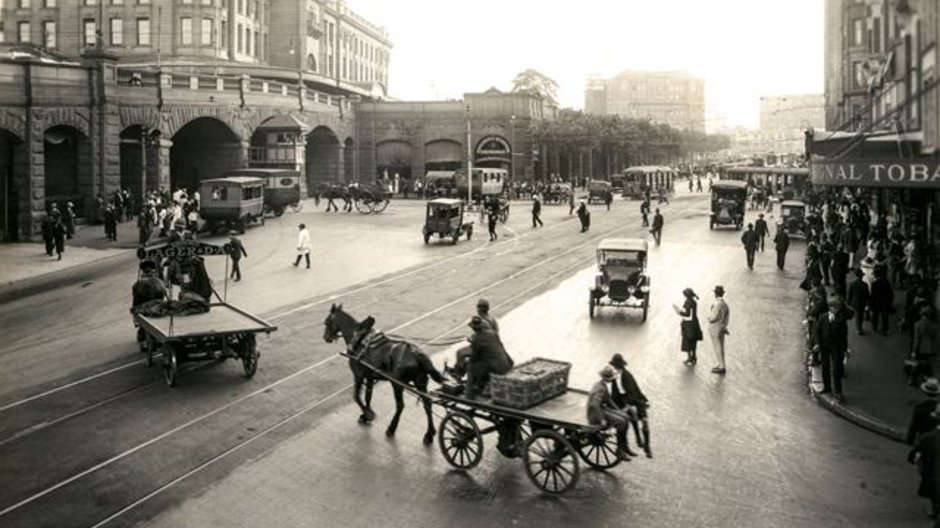 A photo from the City of Sydney Archives: 051080, showing commuters outside of Central station in cars and horse drawn carriages along south of Pitt Street.