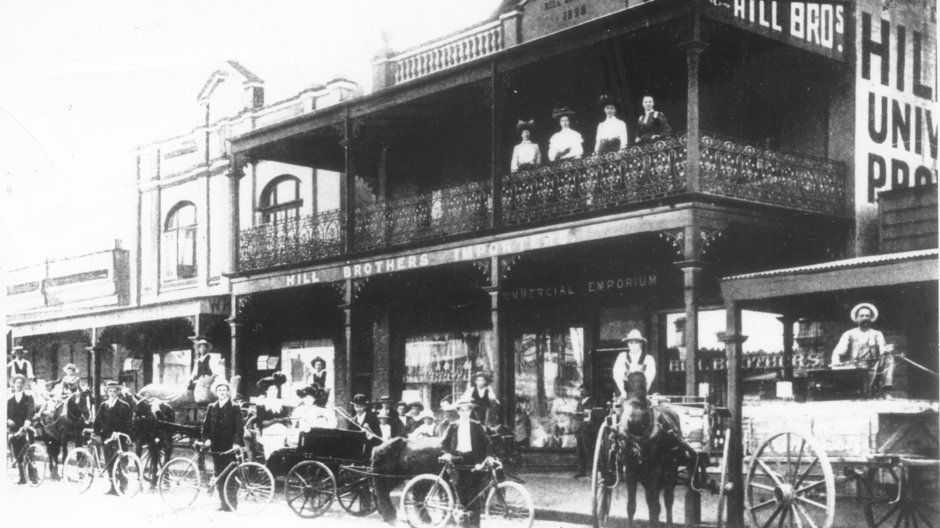 Black and white photo of horse-drawn vehicles and bicycles outside Hill Bros. Importers, Chatswood in 1904