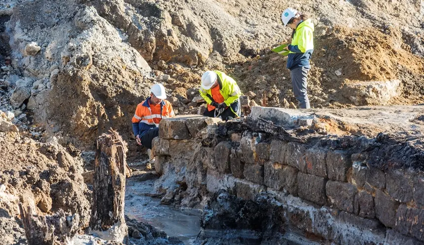 Archaeologists in high vis and hard hats are working in the excavation area at the future site of Barangaroo Metro Station.