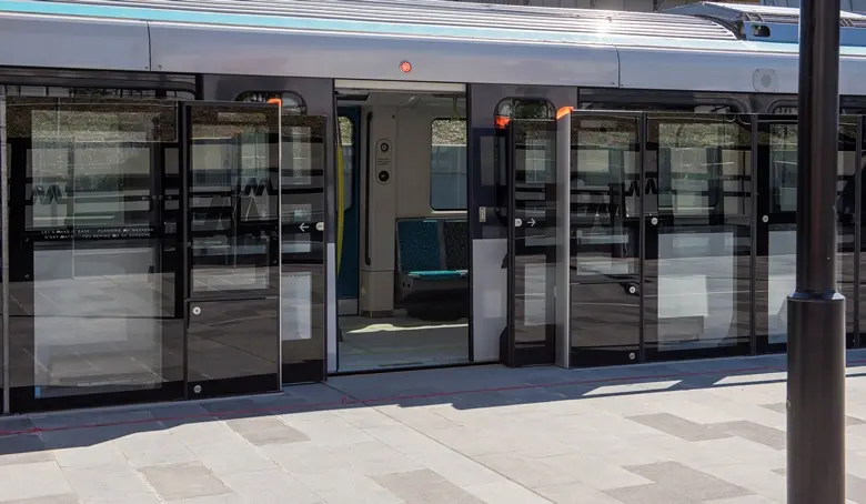 A close up view from the platform displaying the safety screen doors opened as a Sydney Metro train has stopped and opened it's doors at the platform.