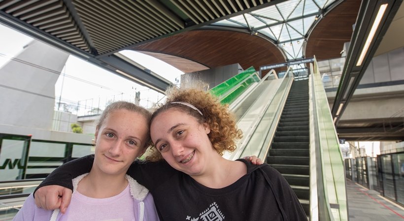 Two members of the community standing in front of the escalators at Sydney Metro's Tallawong Station as part of the community day event.