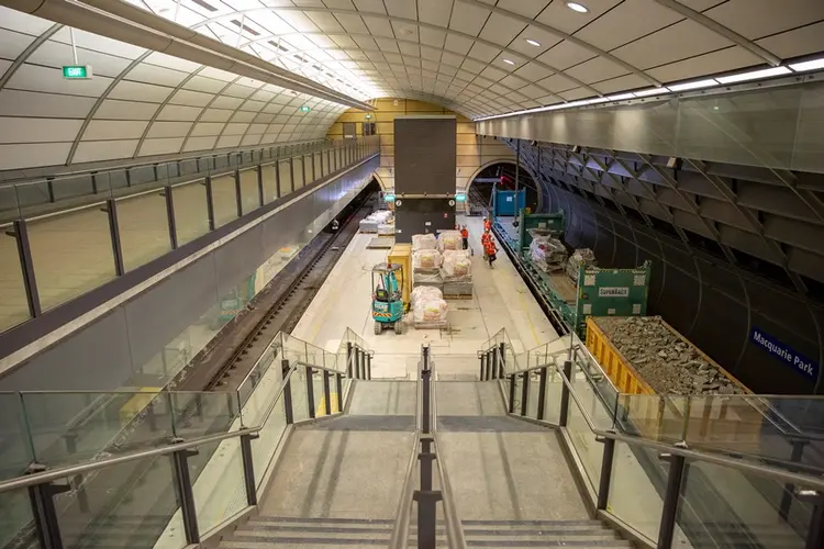 An arial view looking down the station stairs at the platform where a freight train delivering materials to the platform at East Coast Rail Link's Macquarie Park Station.