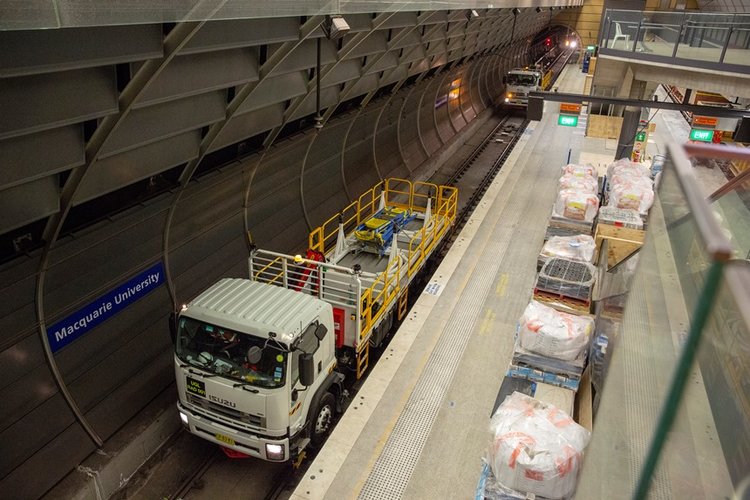 An arial view showing two trucks on the tracks delivering materials to the platform at East Coast Rail Link's Macquarie University Station.