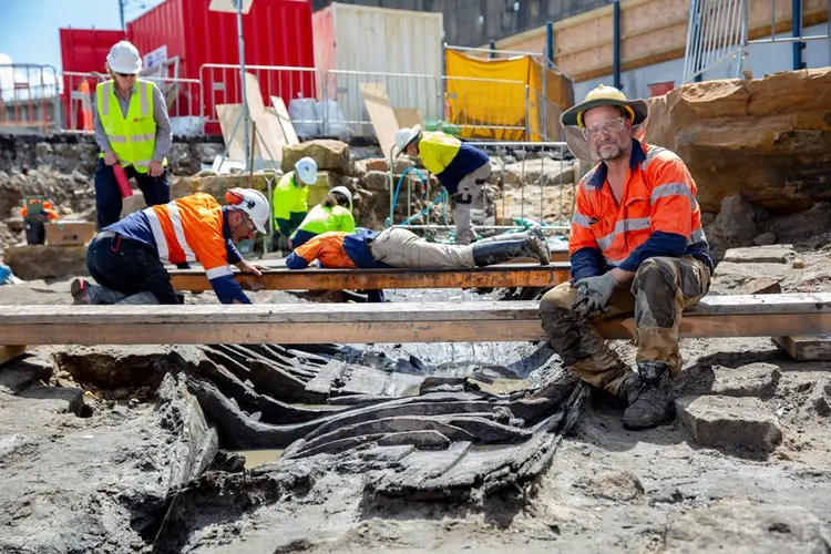 Archaeologists in high vis and hard hats are working in the excavation area at the future site of Barangaroo Metro Station.