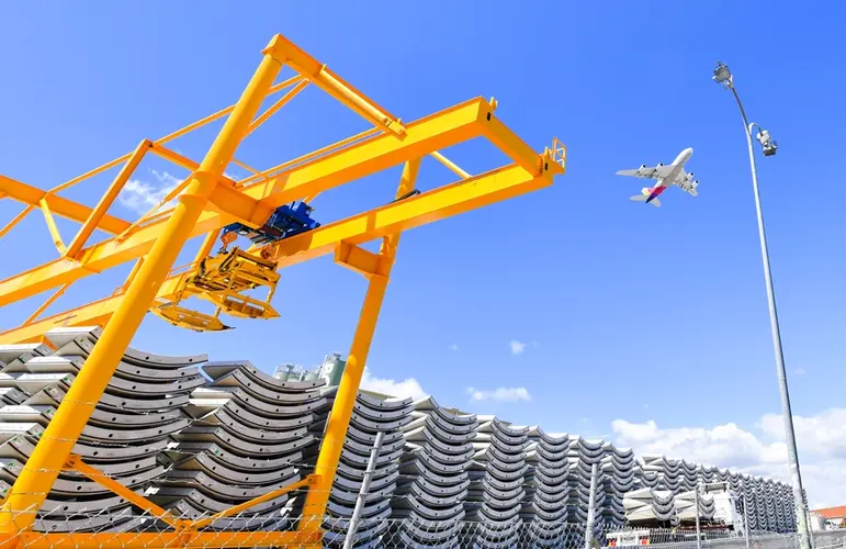 A close up shot of the precast segments piled and lined up ready for installation at Sydney Metro's Marrickville Station the picture is showing a crane above the segments and a plane flying overhead.