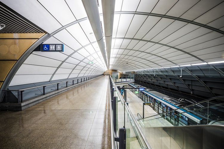 An artist's impression inside of the raised platform side walk showing the platform below as a Sydney Metro train pulls up to North Ride Station platform. 