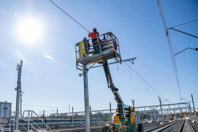 A close up view of construction workers on a cherry picker lift as the overhead works continue as part of the expansion of the Sydney Metro Trains Facility in Rouse Hill.